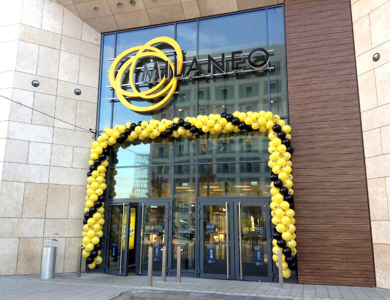 Ballongirlande mit gelben und schwarzen Ballons um den Eingang eines Einkaufszentrums