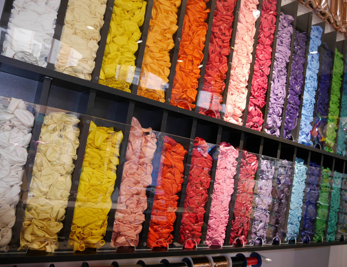 Reihen von vielen, unaufgeblasenen Ballons mit unterschiedlichen Farben